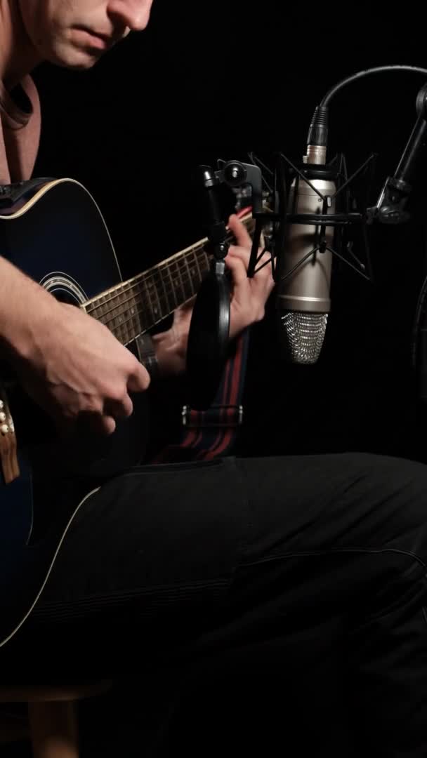 Vertikal video. Akustisk gitarr inspelning på studio mikrofon på svart bakgrund — Stockvideo