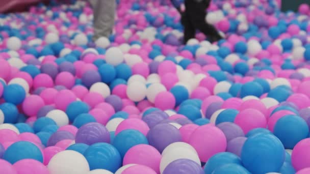 Un montón de bolas multicolores en la piscina en el centro de entretenimiento para niños. — Vídeos de Stock
