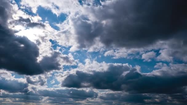 Zeitraffer der grauen Cumuluswolken bewegt sich am blauen Himmel. Sonnenstrahlen scheinen. Wolkenraum — Stockvideo