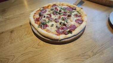 Bir kafedeki Tahta Masa 'da Taze Hazırlanmış Pizza.