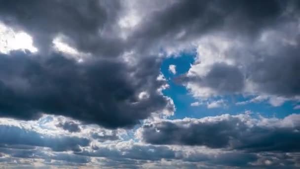 Zeitraffer der grauen Cumuluswolken bewegt sich am blauen Himmel. Sonnenstrahlen scheinen. Wolkenraum — Stockvideo