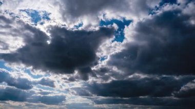 Gri Kümülüs Bulutları Mavi Gök 'te ilerliyor. Güneş ışınları parlıyor. Bulut Alanı
