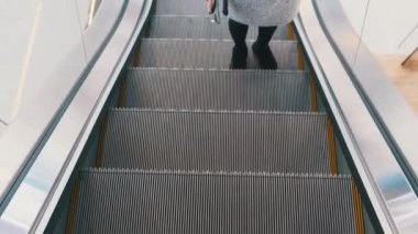 Alışveriş merkezinde boş bir yürüyen merdivenden yükselen bir kadın bacağı manzarası. Alışveriş merkezi.