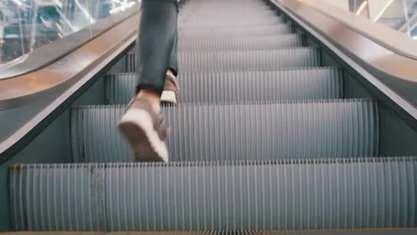 Vista de los pies de la gente subiendo por la escalera mecánica vacía en el centro comercial. Vista inferior. — Vídeos de Stock