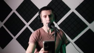 Genç Adam Mikrofon ve Kayıt Stüdyosunda Şarkı Söylüyor