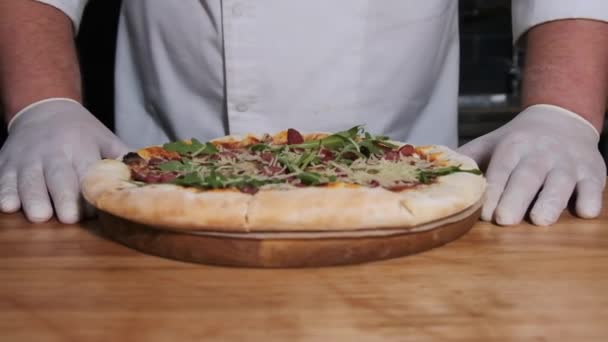 A séf bemutatja a frissen készített pizzát az asztalon az étteremben. Lassú mozgás — Stock videók