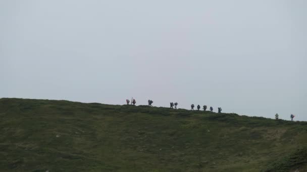 Yürüyüş sırt çantalı bir grup turist dağ sırasına tırmanıyor. Uzaktan Görünüm — Stok video
