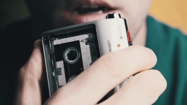 Um jovem está gravando seu discurso em um gravador de cassetes retro portátil — Vídeo de Stock