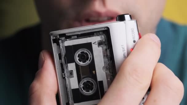 Un giovane sta registrando il suo discorso su un registratore di cassette retrò portatile — Video Stock