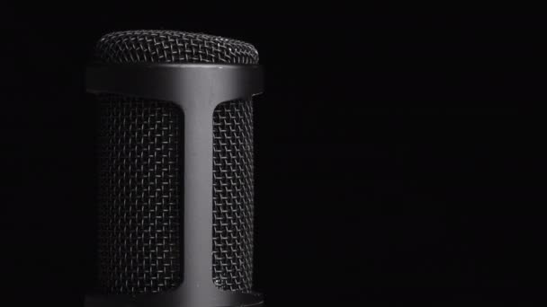 Microfone condensador de estúdio gira em fundo preto com lugar para texto — Vídeo de Stock