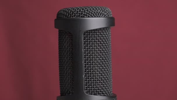 Microfone condensador de estúdio gira em fundo vermelho com lugar para texto — Vídeo de Stock