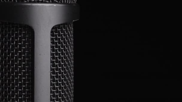 Microfone condensador de estúdio gira em fundo preto com lugar para texto — Vídeo de Stock