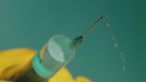 Spritzennadel mit flüssigen Tropfen von Medikamenten in den Händen des Arztes — Stockvideo