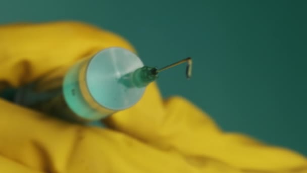 Aiguille de seringue avec gouttes liquides gouttes de médicament dans les mains du médecin — Video