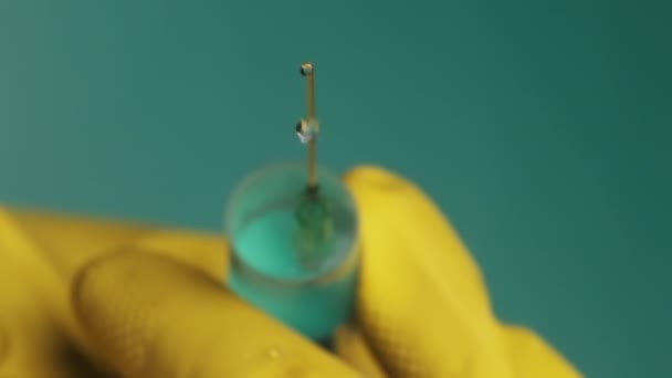 Agulha de seringa com gotas de medicação de gotejamento líquido em mãos de médico — Vídeo de Stock
