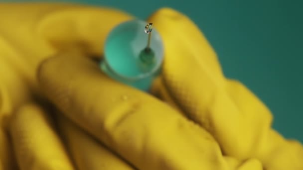 Agulha de seringa com gotas de medicação de gotejamento líquido em mãos de médico — Vídeo de Stock