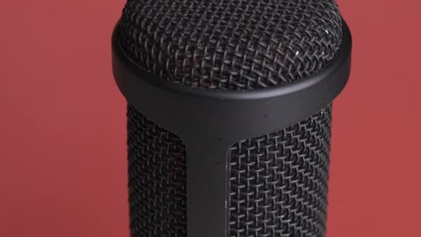 Microfone condensador de estúdio gira em fundo vermelho com lugar para texto — Vídeo de Stock