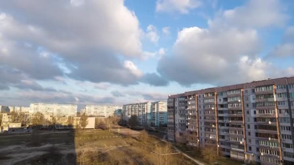 В голубом небе над многоэтажными зданиями в городе сгущаются тучи — стоковое видео