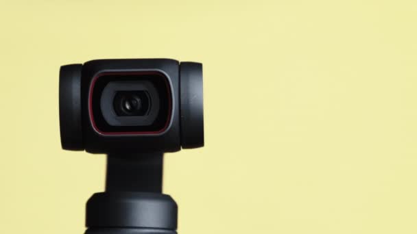 Объектив механической камеры Gimbal вращается на желтом фоне, макрос роботизированной камеры — стоковое видео