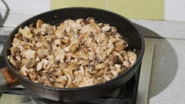 Ev Mutfağında sıcak tavada kızartılmış mantara süt kreması ekliyorum. Julienne.