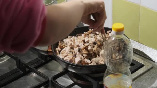 होम किचनमध्ये चीज आणि मांससह फ्रीड मशरूम तयार करणारी तरुण महिला — स्टॉक व्हिडिओ