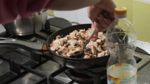 Mujer joven preparando setas fritas con queso y carne en la cocina casera — Vídeo de stock