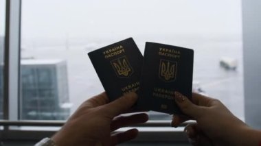 Ukrayna pasaportu havaalanındaki bir çift gezginin elinde, kalkış.