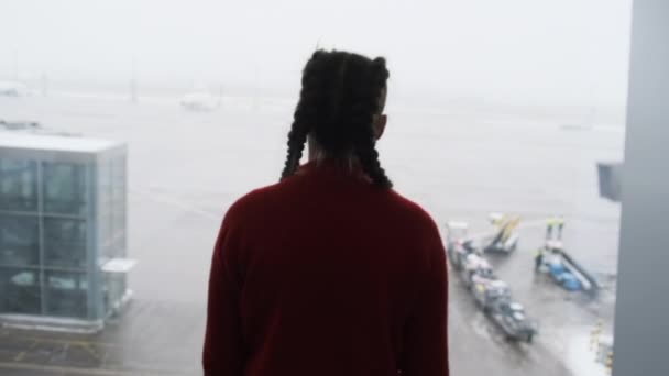Silhouet van een gemaskerde jonge vrouw op het vliegveld Terminal Window op zoek naar vliegtuigen — Stockvideo