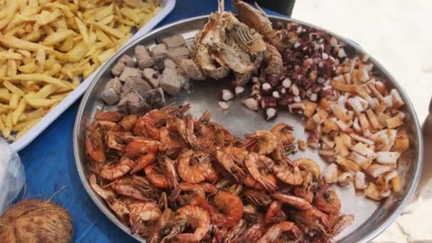 Плита экзотических морепродуктов креветки, кальмары, осьминога, тунца рыбы и картошки фри на пляже — стоковое видео