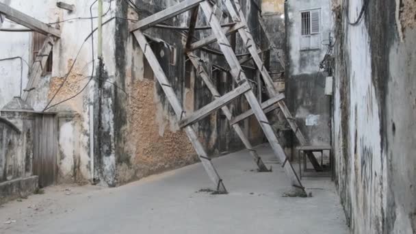 Dilapiderade gamla hus Stöds av träbjälkar i Stone Town, Zanzibar, Afrika — Stockvideo