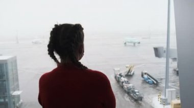 Havaalanı Terminalinde Uçağı izleyen Maskeli Genç Bir Kadının Silueti