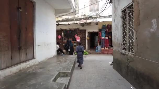 Recorrido a pie por la ciudad de piedra, Zanzíbar, Calles estrechas y sucias con africanos pobres — Vídeo de stock