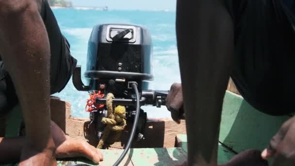 Afrikanska kontroller av utombordsmotorn på en gammal fiskebåt, Zanzibar, Tanzania — Stockvideo