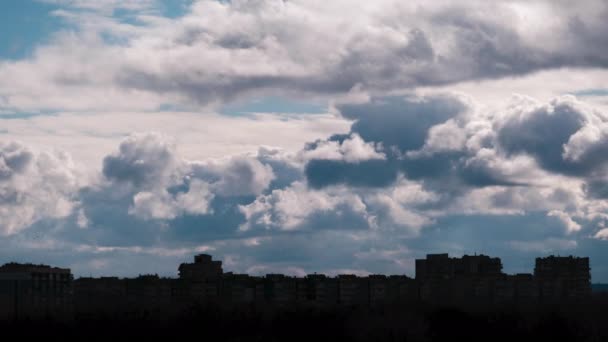 A Cumulus Clouds időrendje a magasan emelkedő épületek sziluettjei felett mozog — Stock videók