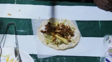 Bir satış şefi Stone Town gece pazarında bir Zanzibar shawarma hazırlıyor..