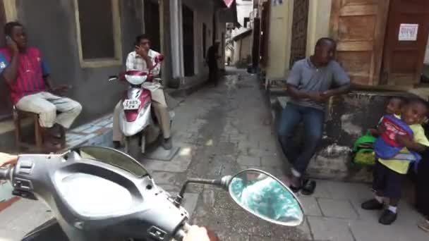 Cavalcare uno scooter di Narrow Dirty Streets of Stone Town con i poveri africani — Video Stock