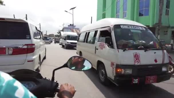 Scooter a caballo por carretera africana ocupada con tráfico a la izquierda, Stone Town, Zanzíbar — Vídeo de stock