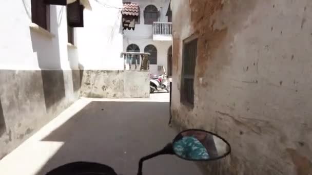 Monter un scooter par étroites rues sales de Stone Town avec les pauvres Africains — Video