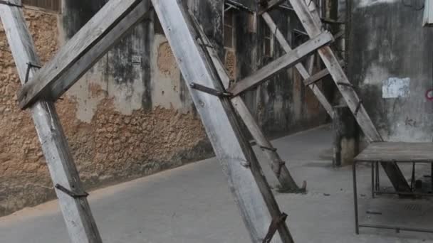 Поврежденные старые дома, поддерживаемые деревянными балками в Стоун-тауне, Занзибар, Африка — стоковое видео