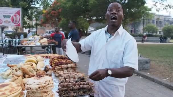 Forodhani Food Stalls, um vendedor africano anuncia seu mercado de alimentos Zanzibar — Vídeo de Stock