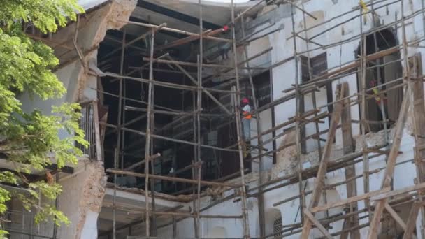 アフリカの建築家は、アフリカのザンジバルの石の町にある崩れかけた建物を再建する. — ストック動画