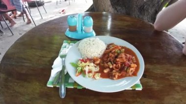 Zanzibar 'daki yerel yemekler. Pirinç, körili deniz ürünleri, ucuz caddedeki kafede tabakta salata.
