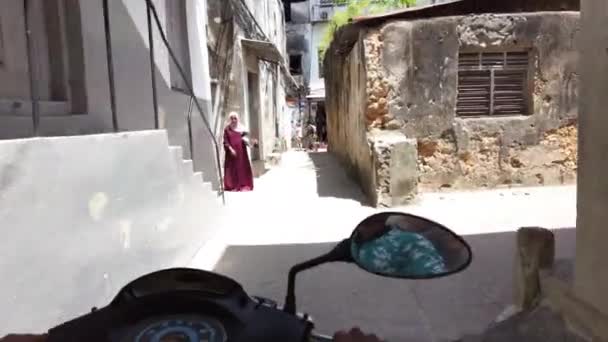 Rida en skoter av smala smutsiga gator i Stone Town med fattiga afrikaner — Stockvideo