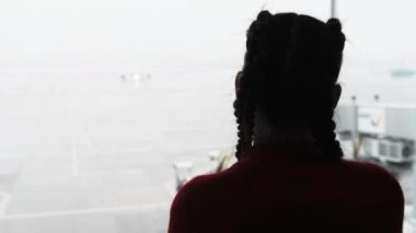 Havaalanı Terminalinde Uçağı izleyen Maskeli Genç Bir Kadının Silueti