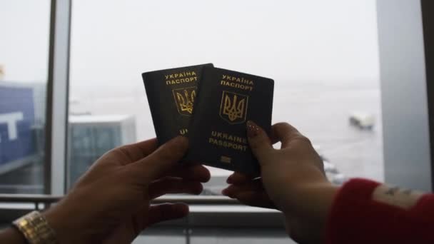 Українські паспорти в руках пари мандрівників в аеропорту "Відхід" — стокове відео