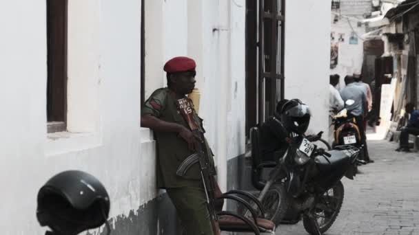 Un soldat africain armé avec une mitrailleuse dans la rue dans la région pauvre d'Afrique — Video