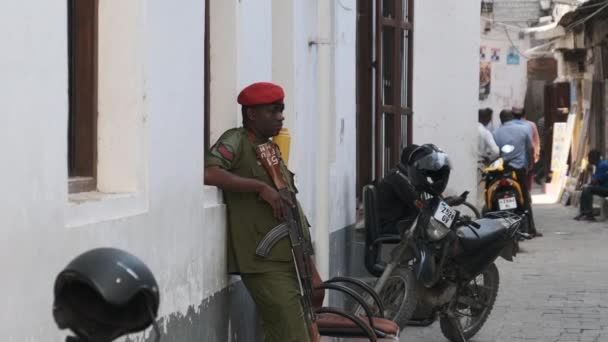 En beväpnad afrikansk soldat med maskingevär på gatan i fattiga regionen i Afrika — Stockvideo