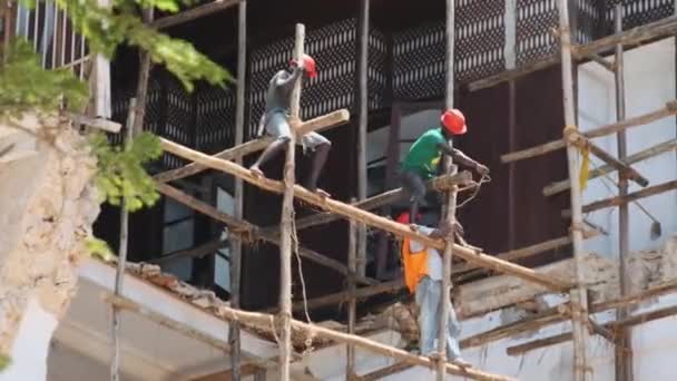 Constructores africanos reconstruyen un edificio en ruinas en Stone Town, Zanzíbar, África. — Vídeos de Stock