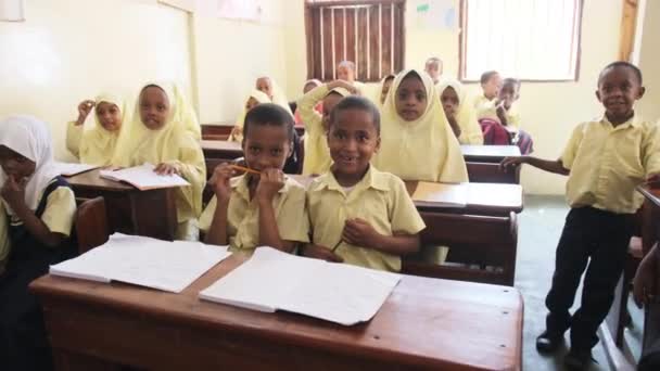 Barn i en afrikansk grundskola sitter på skrivbord i ett klassrum, Zanzibar — Stockvideo