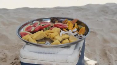 Bir tabak egzotik meyve ananas, karpuz, hindistan cevizi, mango, tropik plajda.